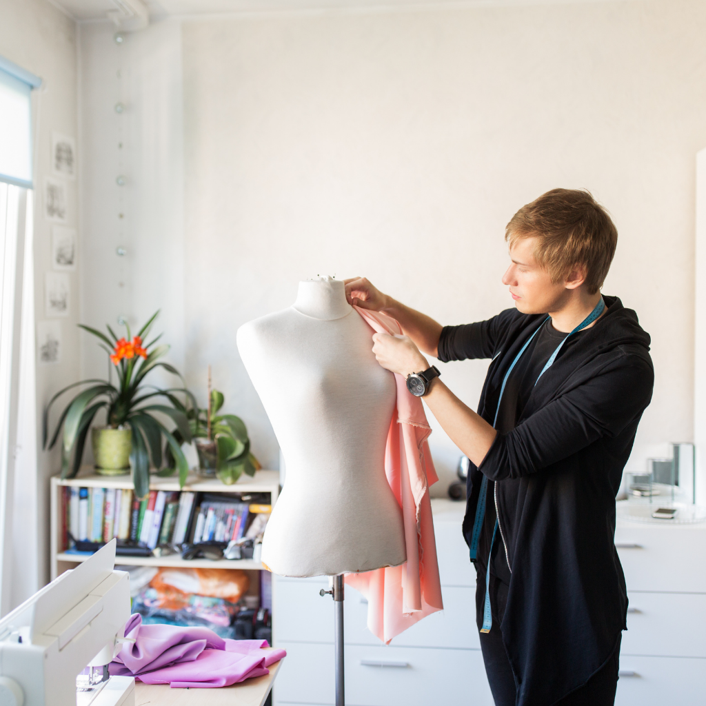 man measuring dressform with fabric