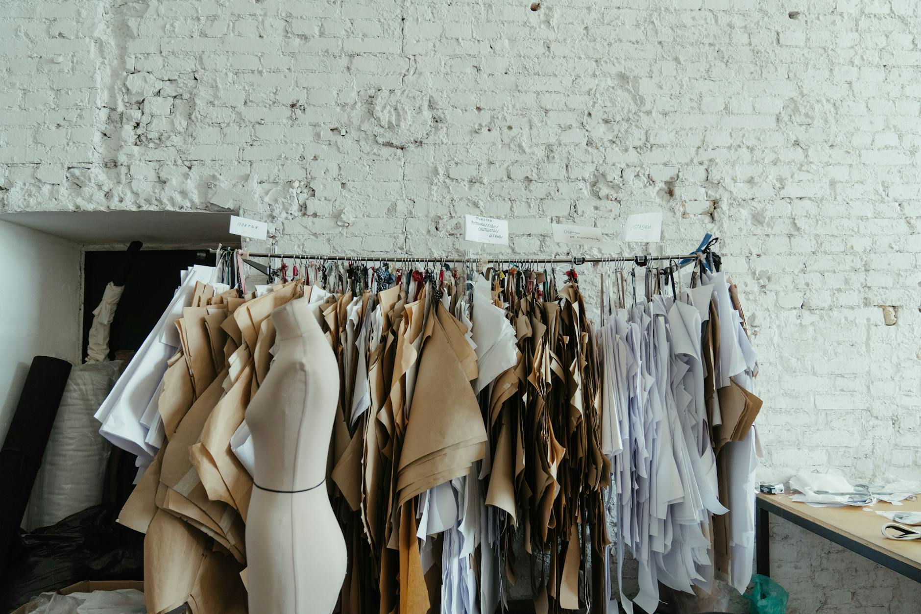 sewing patterns designed by fashion designer hanging up on hooks
