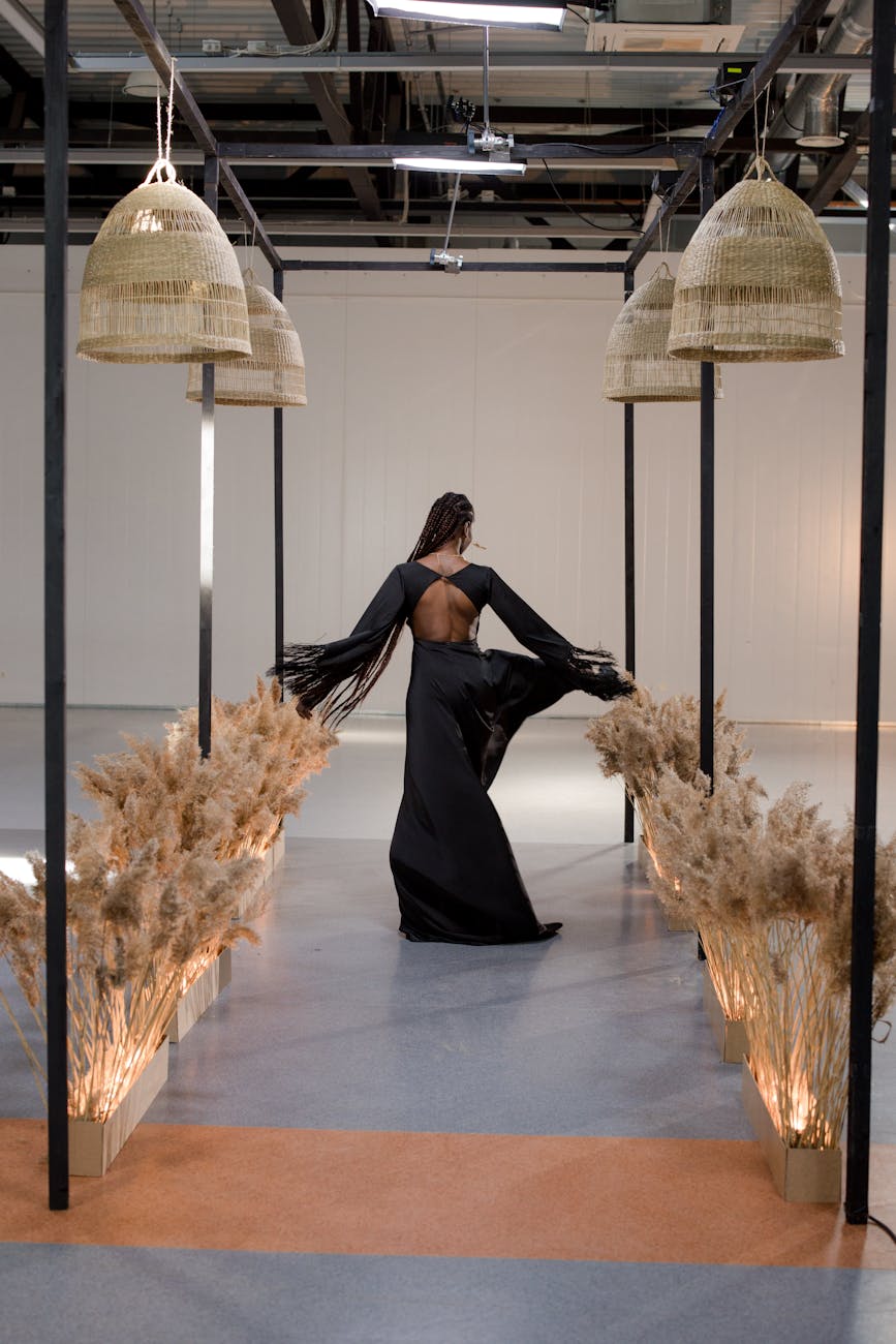 woman in a black dress at a fashion show, walking on a fashion runway